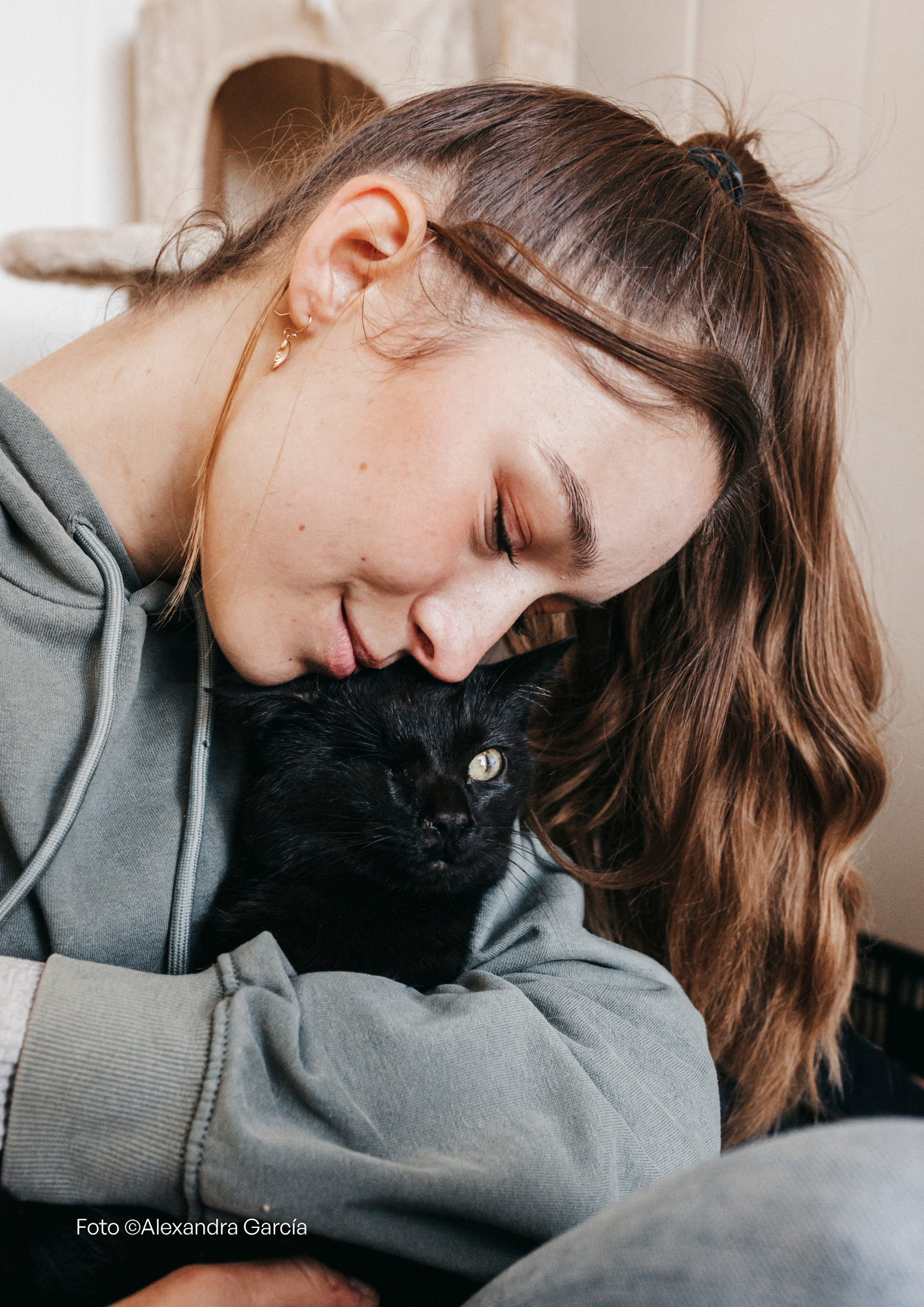 Luca, una voluntaria de Salvando Peludos junto al gato negro Lajo.
